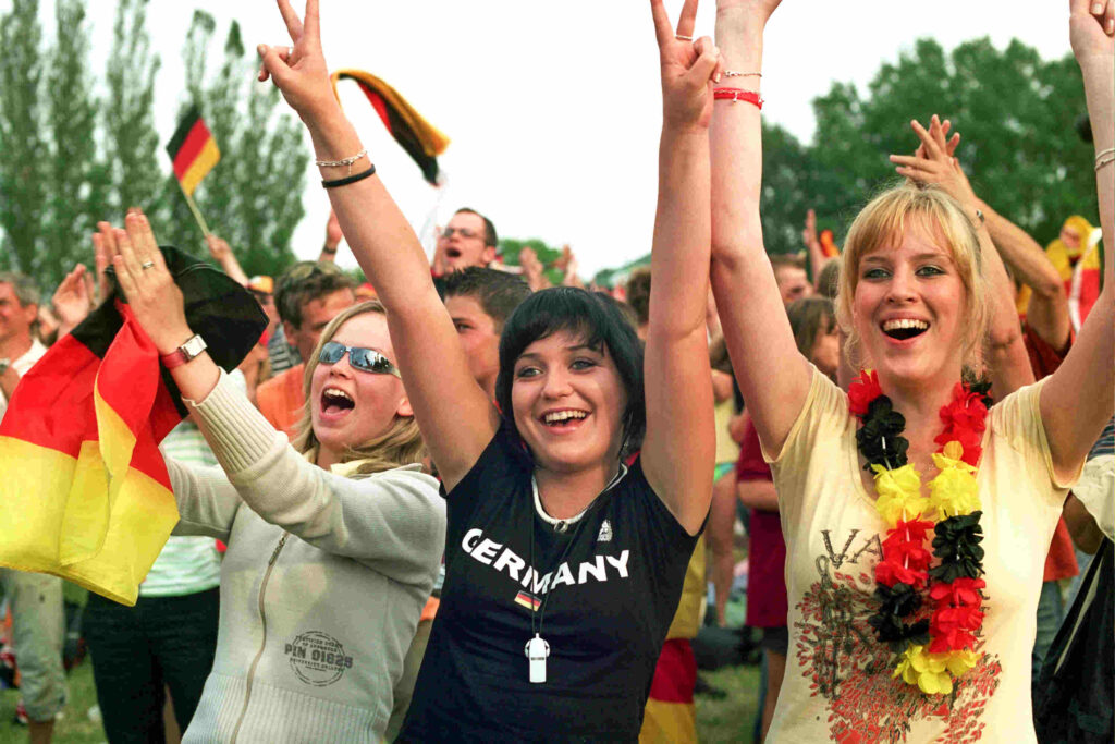 Jubelnde Menschen mit Fahnen bei der WM 2006.
